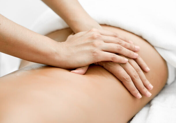 Young woman receiving a back massage in a spa center. Female patient is receiving treatment by professional therapist.